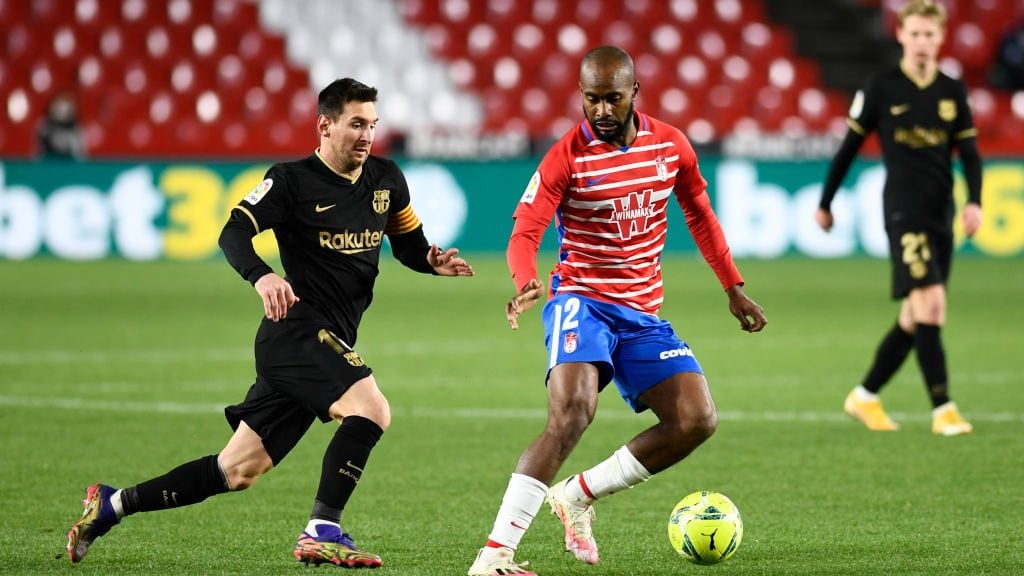 GRANADA, SPAIN - 2021/01/09: FC Barcelona player Lionel Messi and Granada CF player Dimitri Foulquier are seen in action during the La Liga Santander match between Granada CF and FC Barcelona at Nuevo Los Carmenes stadium in Granada.(Final Score; Granada CF 0:4 FC Barcelona). (Photo by Carlos Gil/SOPA Images/LightRocket via Getty Images)
