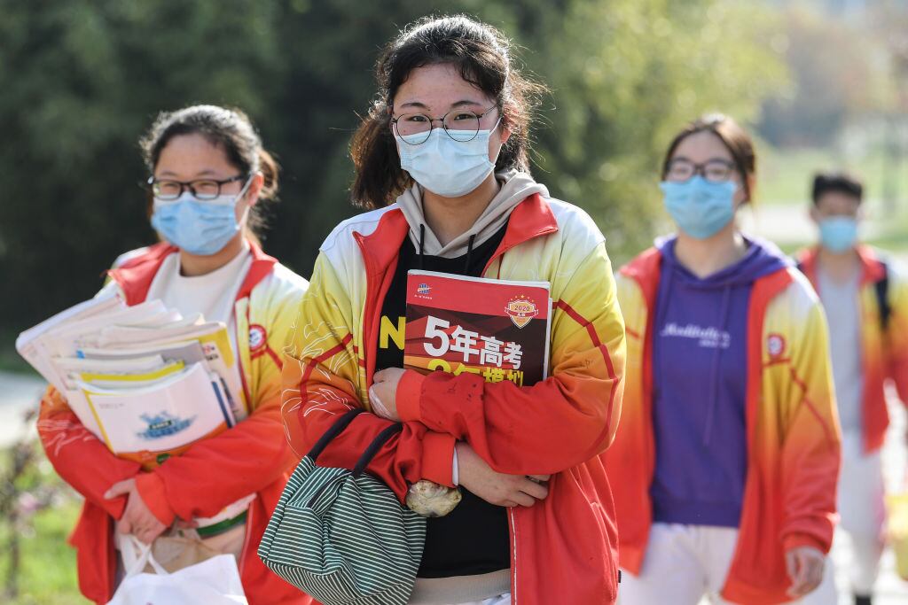 Tres estudiantes llegan a su escuela utilizando máscaras en la ciudad china de Bozhou
