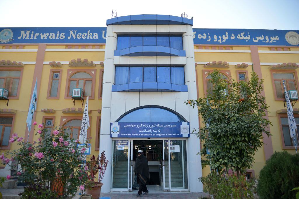 Mujer camina afuera de la Universidad de Kandahar en Afganistán