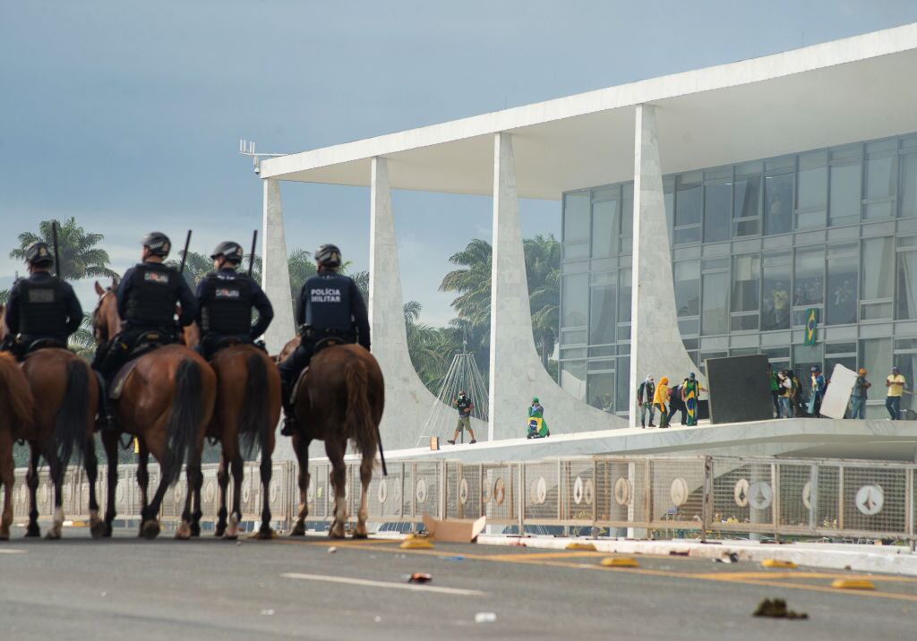 Policías ven cuando los ultraderechistas atacan el palacio de gobierno de Brasil
