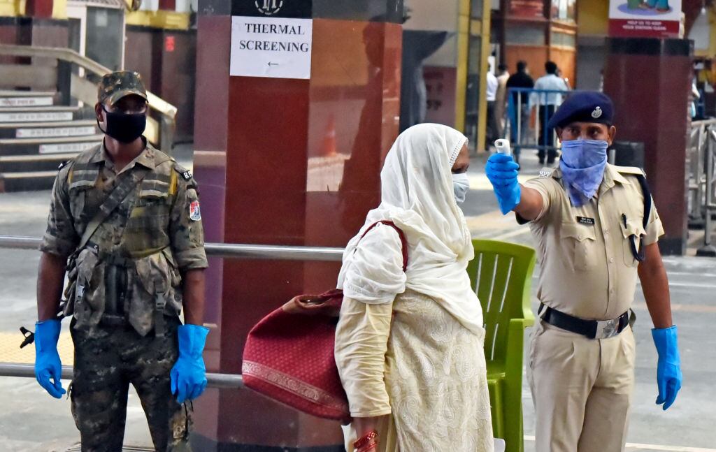 Un guardia controla la temperatura en una estación de trenes en India