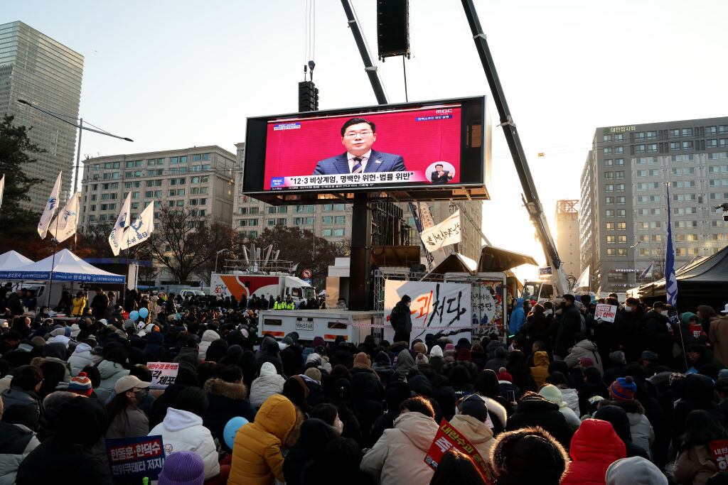 La imagen del presidente de Corea del Sur, Yoon Suk Yeol, en una pantalla gigante en las calles de Seúl mientras el parlamento votaba su destitución