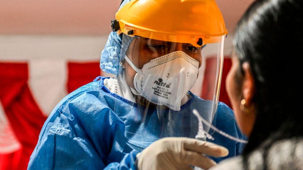 A health worker takes a sample for a COVID-19 test at a patient's home in Medellin, Colombia on May 8, 2020. (Photo by JOAQUIN SARMIENTO / AFP) (Photo by JOAQUIN SARMIENTO/AFP via Getty Images)