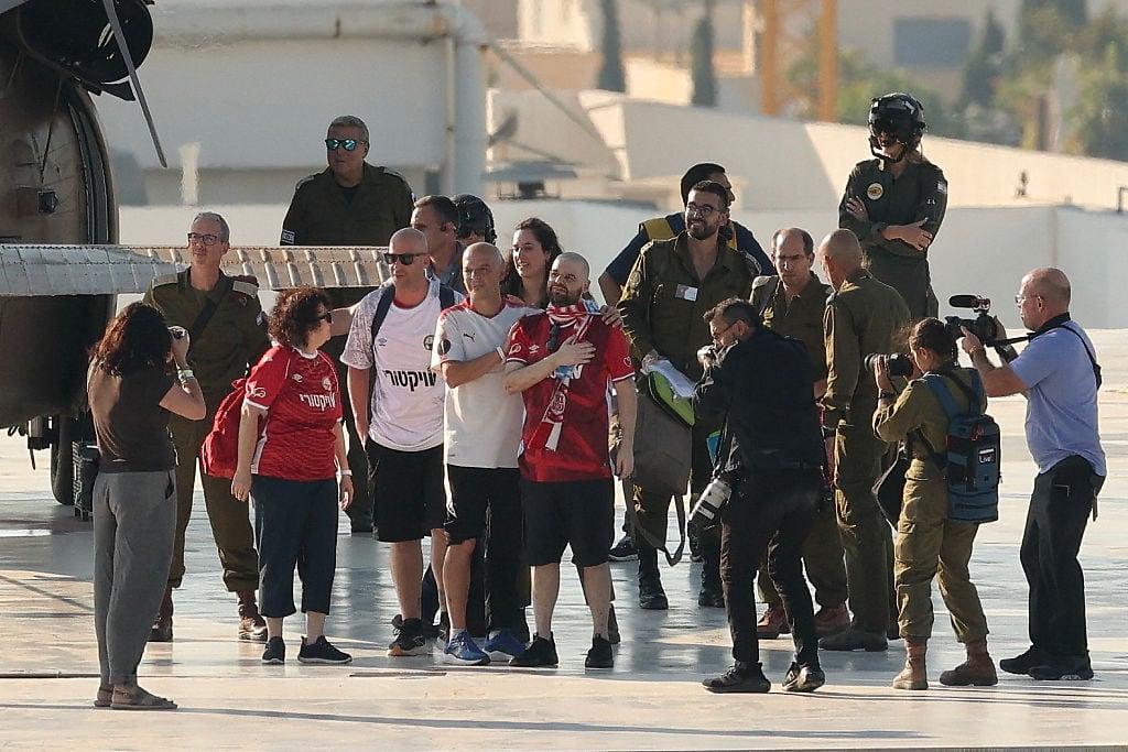 Former Israeli hostage Eitan Horn (C) gestures upon disembarking from an Israeli military helicopter on the landing pad at Ichilov Sourasky Medical Centre in Tel Aviv on October 13, 2025. Twenty living Israeli hostages were released on October 13 after more than two years in captivity in Gaza, as part of a ceasefire deal with Hamas. Militants kidnapped them during Hamas's October 7, 2023 attack on Israel, the deadliest in the country's history. (Photo by Jack GUEZ / AFP) (Photo by JACK GUEZ/AFP via Getty Images)          