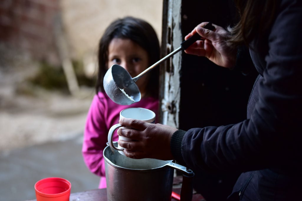 En la zona de Quilmes en Argentina una niña espera que le entreguen comida en una olla común. Imagen referencial.