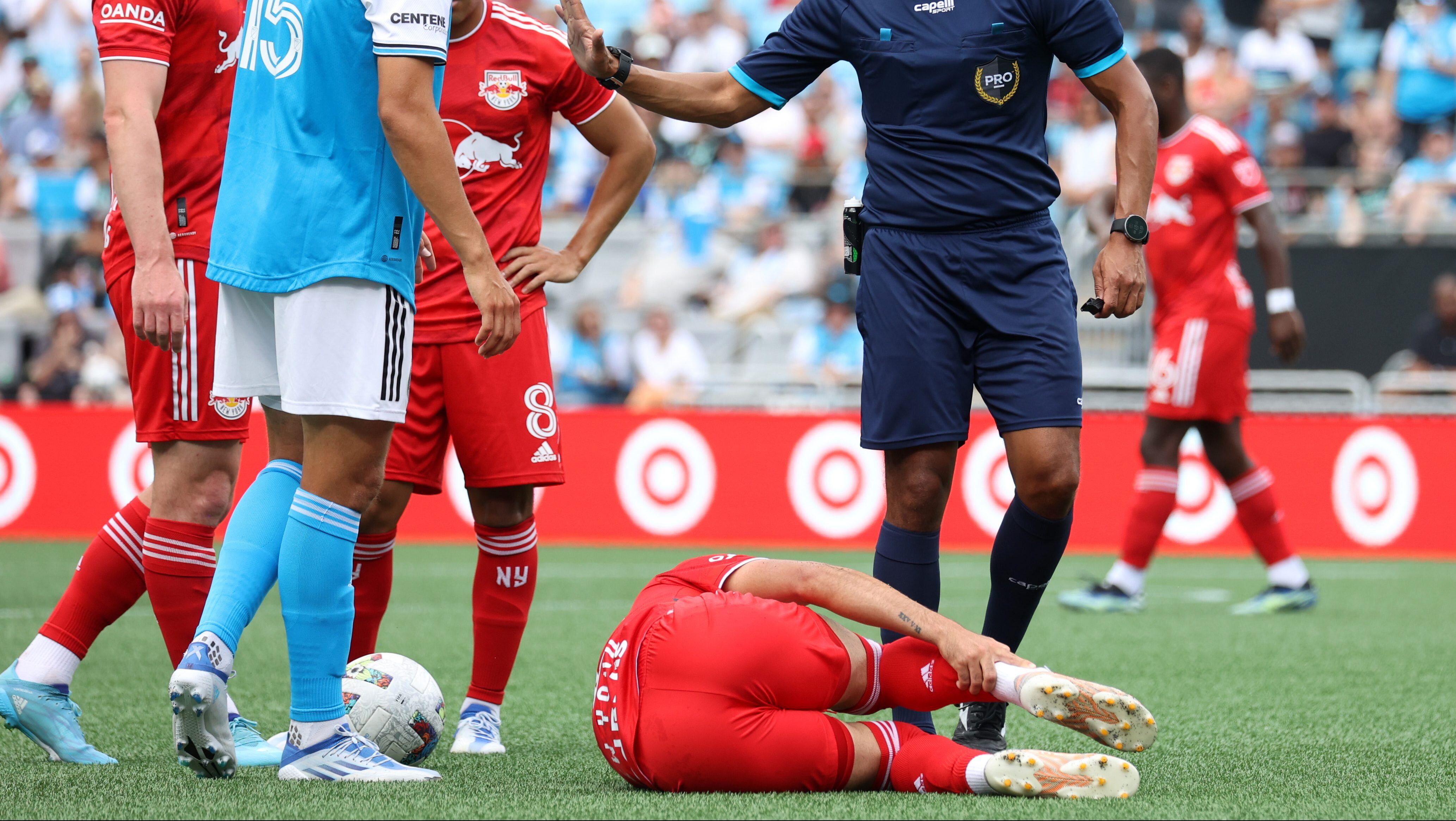 CHARLOTTE, NC - JUNE 11 Referee Guido Gonzales Jr talks to Ben Bender #15 of Charlotte FC after his foul on Luquinhas #82 of the New York Red Bulls during a game between New York Red Bulls and Charlotte FC at Bank of America Stadium on June 11, 2022 in Charlotte, North Carolina. (Photo by Andy Mead/ISI Photos/Getty Images)