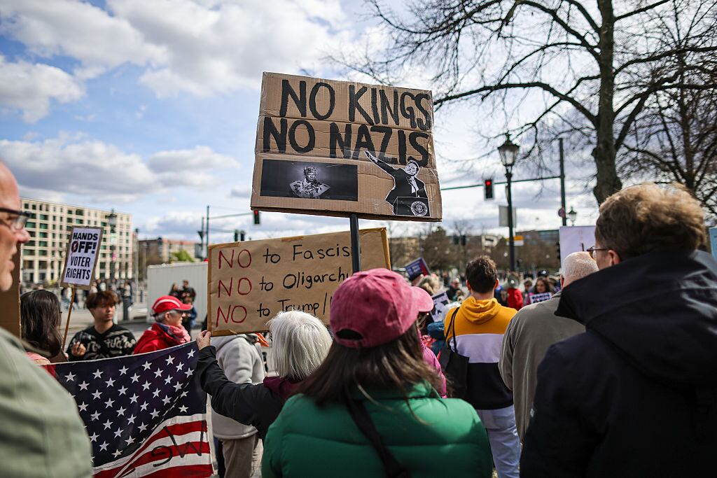 BERLIN, GERMANY - APRIL 5: A demonstrator holds a banner reading "NO KINGS NO NAZIS" as people protest outside the U.S. Embassy against U.S. President Donald Trump and Trump advisor Elon Musk on April 5, 2025 in Berlin, Germany. Many people across Europe are upset over Trump's confrontational course against the European Union and its traditional U.S. allies. Musk has repelled many people in Europe, and in Germany in particular, through his vocal support for far-right political parties, including the Alternative for Germany (AfD). (Photo by Omer Messinger/Getty Images)