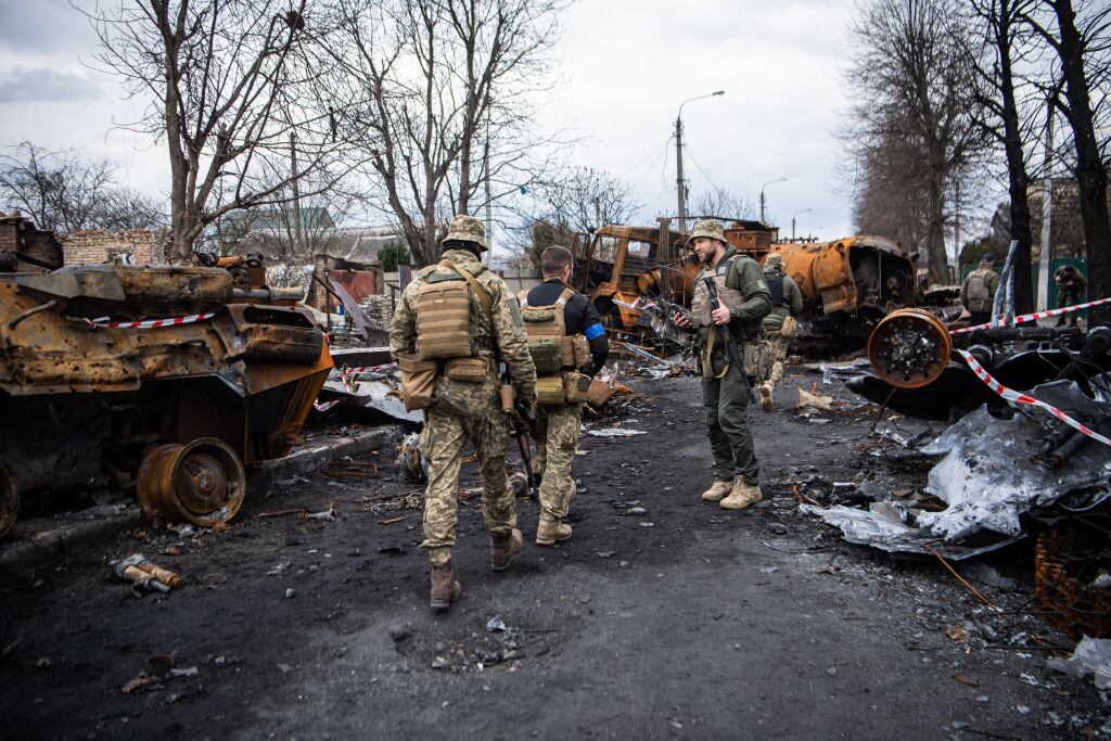 Soldados ucranianos observan vehículos militares destruidos en Kiev