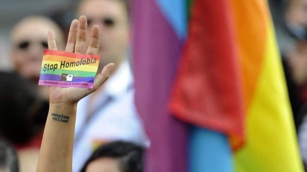 A demonstrator brandishes a rainbow flag sticker as he protests against homophobia and repression against gays in Russia, outside the Ministry of Foreign Affairs and Cooperation in Madrid on  September 3, 2013.  About 300 gay rights activists rallied in Madrid today as part of an international protest against hotly disputed Russian laws cracking down on homosexual behaviour.  AFP PHOTO/ CURTO DE LA TORRE        (Photo credit should read CURTO DE LA TORRE/AFP via Getty Images)