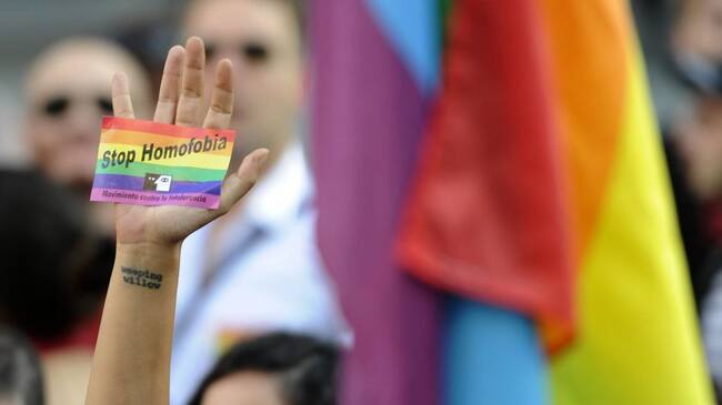A demonstrator brandishes a rainbow flag sticker as he protests against homophobia and repression against gays in Russia, outside the Ministry of Foreign Affairs and Cooperation in Madrid on September 3, 2013. About 300 gay rights activists rallied in Madrid today as part of an international protest against hotly disputed Russian laws cracking down on homosexual behaviour. AFP PHOTO/ CURTO DE LA TORRE (Photo credit should read CURTO DE LA TORRE/AFP via Getty Images)