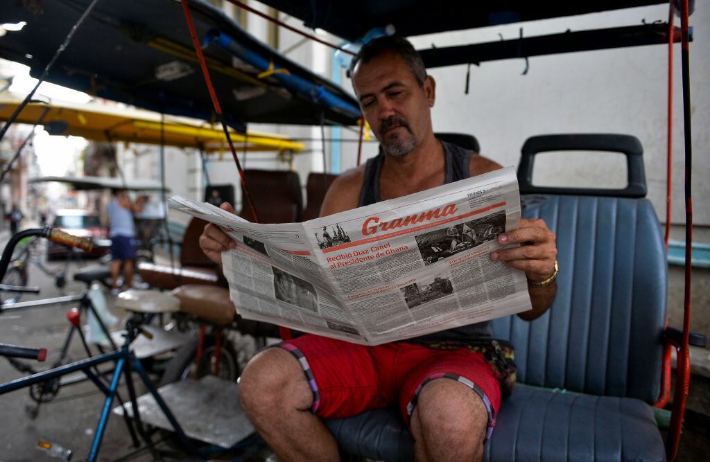 Un trabajador cubano lee el diario estatal Granma en la isla