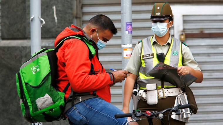 SANTIAGO, CHILE - APRIL 05: Police officers checks for a permit to circulate during quarantine on April 5, 2021 in Santiago, Chile. The Andean country will close its international borders and cancel flights during April after passing one million reported cases of COVID-19. In addition, authorities advance the daily curfew from 10PM to 9PM and limit some activities previously considered essential. (Photo by Marcelo Hernandez/Getty Images)