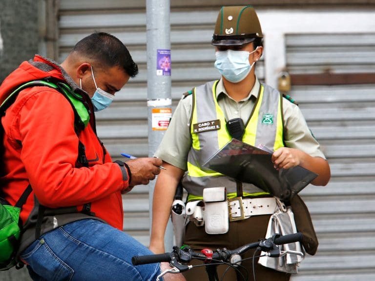 SANTIAGO, CHILE - APRIL 05: Police officers checks for a permit to circulate during quarantine on April 5, 2021 in Santiago, Chile. The Andean country will close its international borders and cancel flights during April after passing one million reported cases of COVID-19. In addition, authorities advance the daily curfew from 10PM to 9PM and limit some activities previously considered essential. (Photo by Marcelo Hernandez/Getty Images)