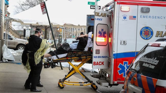 NEW YORK, USA - MARCH 25: A patient with a face mask is being carried to an ambulance at the Maimonides Medical Center in Brooklyn, New York, United States on March 25, 2020. The coronavirus-related deaths in the U.S. topped 800 on Wednesday, while the number of cases reached over 55,200, according to latest figures by Johns Hopkins University. (Photo by Tayfun Coskun/Anadolu Agency via Getty Images)