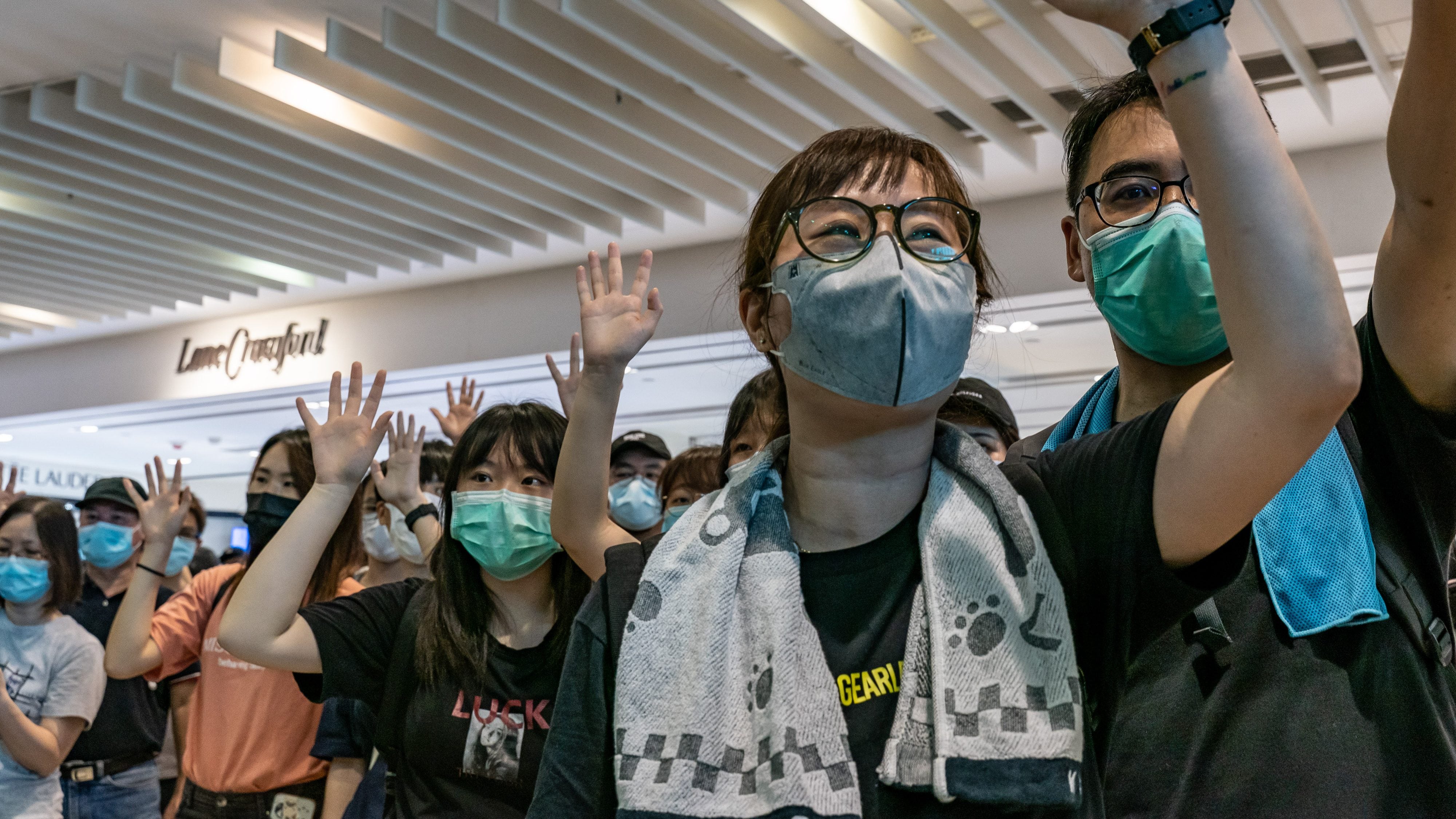 HONG KONG, CHINA - MAY 10:  Anti-government protesters wearing protective masks sing songs and make gestures during a demonstration at a shopping mall on May 10, 2020 in Hong Kong, China. Since the worst of the current coronavirus pandemic has passed, new anti-government protests have recently started to reappear in Hong Kong. (Photo by Anthony Kwan/Getty Images)