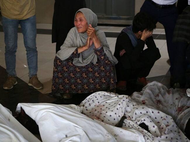 Familiares lloran junto a los cuerpos de los fallecidos en atentado en Kabul