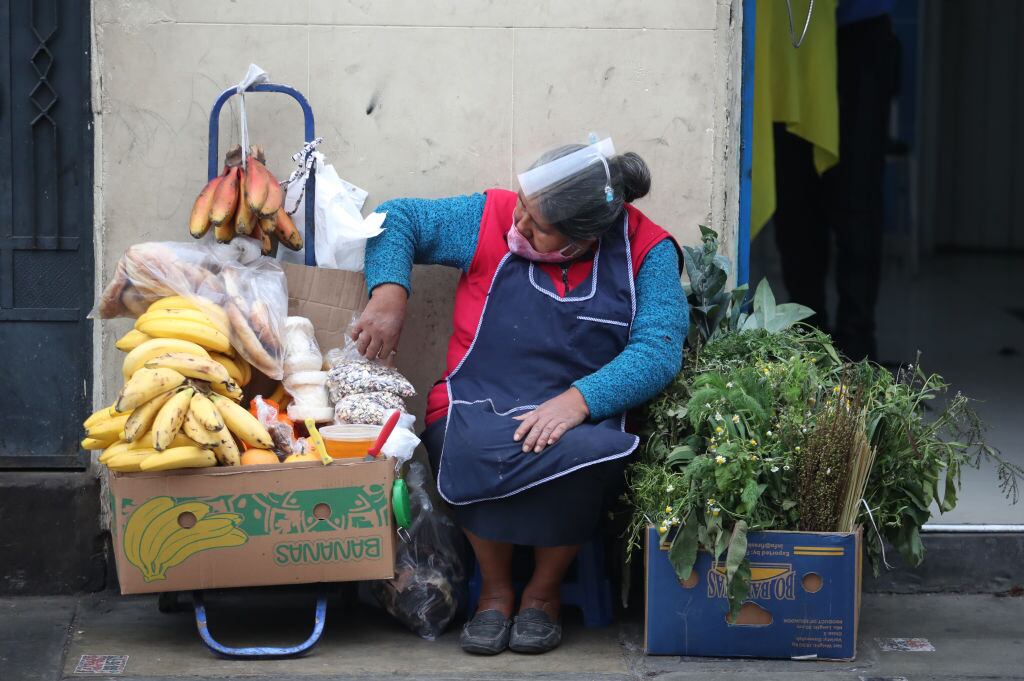 Una mujer vende alimentos en una calle de Lima