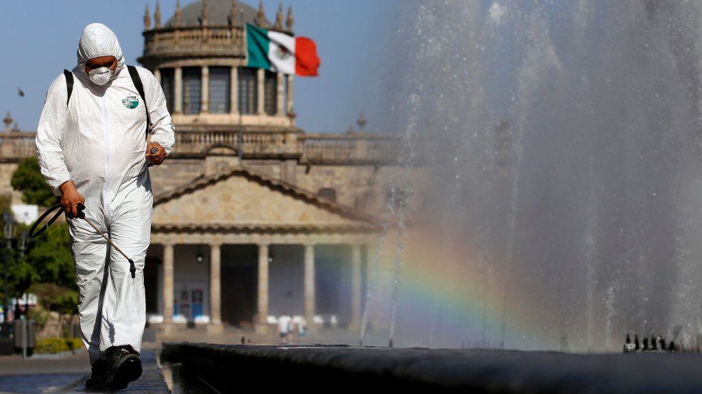 TOPSHOT - A worker wearing a protective suit sprays disinfectant during a campaign to sanitize public spaces as a preventive measure against the spread of the new coronavirus, COVID-19, in Guadalajara, Mexico, on March 20, 2020. (Photo by ULISES RUIZ / AFP) (Photo by ULISES RUIZ/AFP via Getty Images)