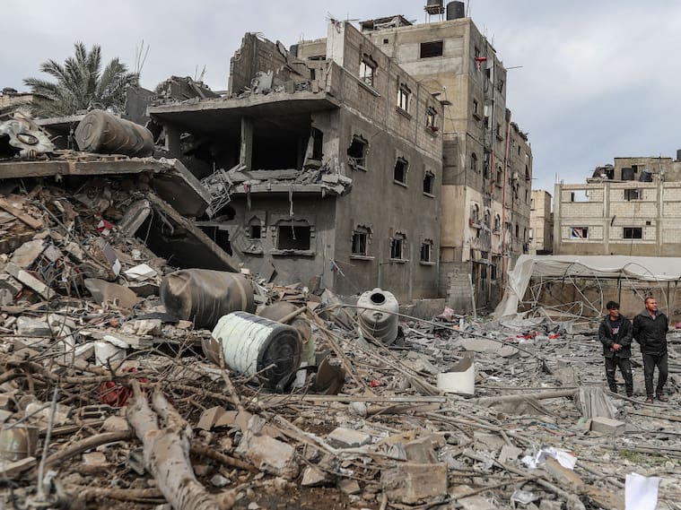 Personas caminan cerca de edificios y estructuras destruidas por Israel con los bombardeos sobre Rafah, en la zona sur de la Franja de Gaza en Palestina.