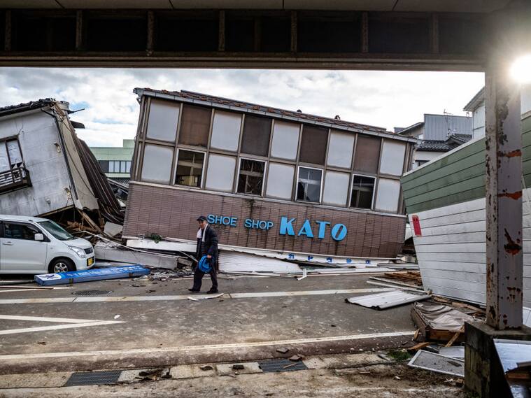 Un hombre camina ante una tienda destruida en la ciudad de Anamizu, una de las consecuencias que deja el terremoto que golpeó a Japón.
