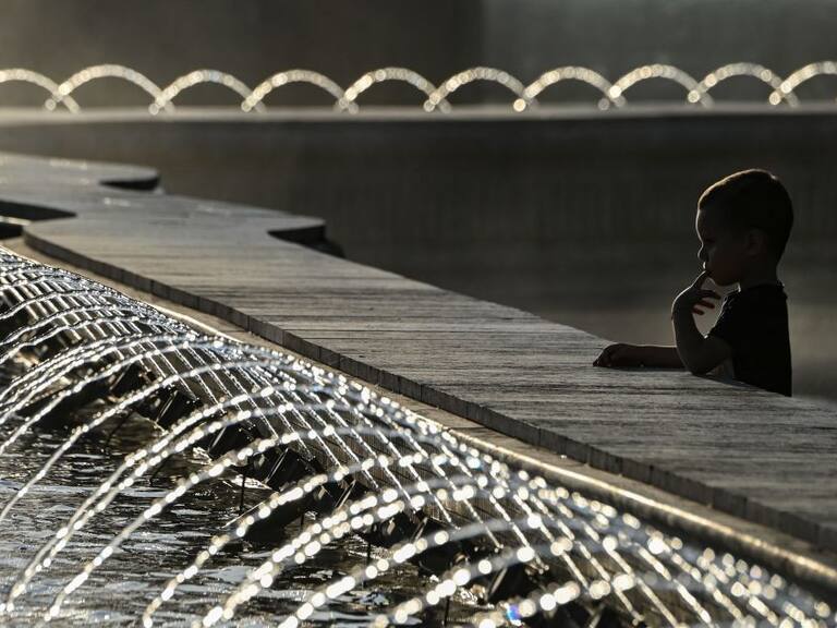 Un niño se acerca el agua ante las altas temperaturas en Bucarest