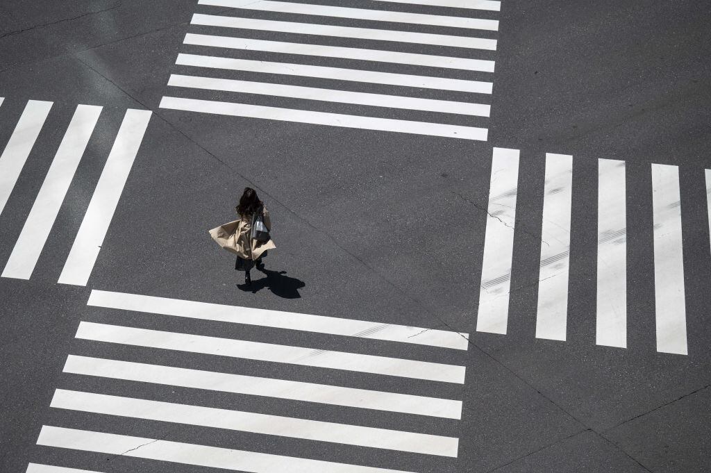 Una mujer camina en solitario por una concurrida zona de Tokio