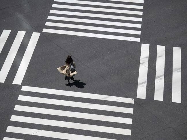 Una mujer camina en solitario por una concurrida zona de Tokio