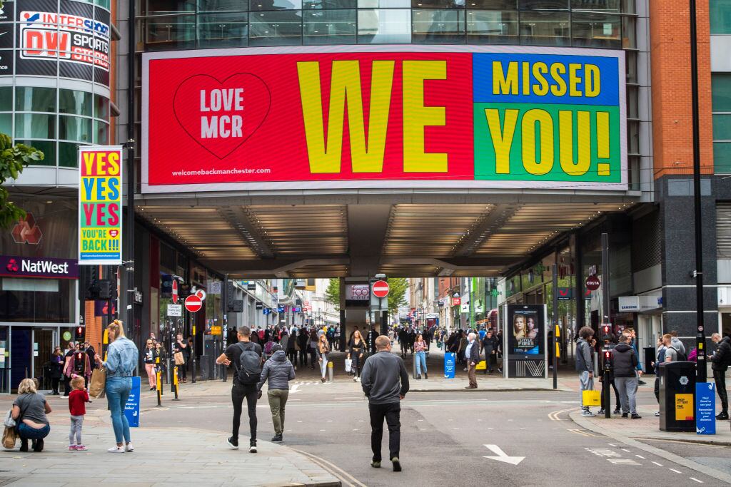 Las personas compran en la zona comercial de Manchester