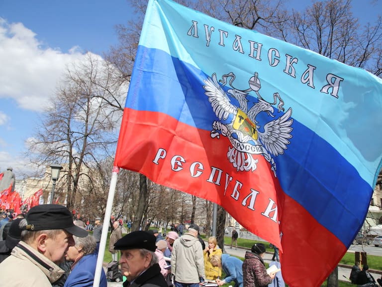 Hombre lleva una bandera de la autoproclamada República de Lugansk