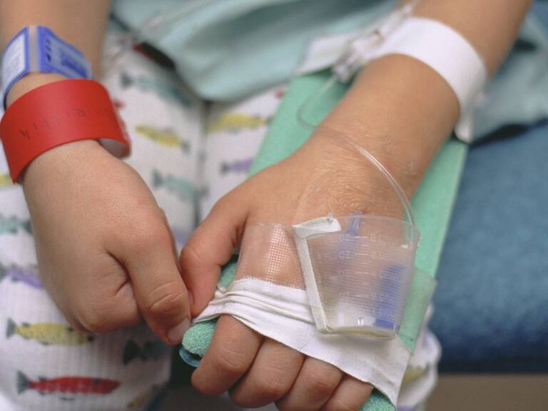 A worried young boy in a hospital bed being treated for croup.The red bracelet is to notify healthcare professionals of an allergy to penicillin.