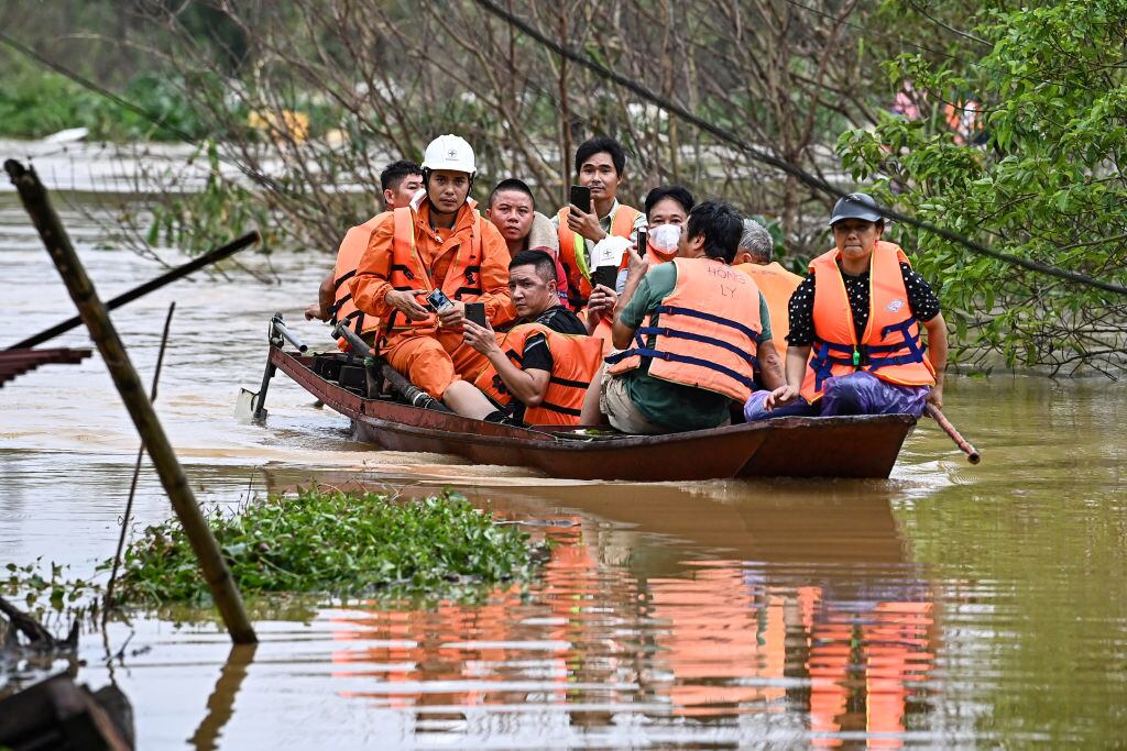 Rescatistas ayudan a evacuar a personas en los alrededores de la ciudad de Hanói en Vietnam tras el paso del supertifón Yagi