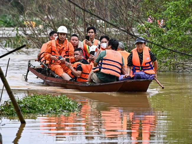 Rescatistas ayudan a evacuar a personas en los alrededores de la ciudad de Hanói en Vietnam tras el paso del supertifón Yagi