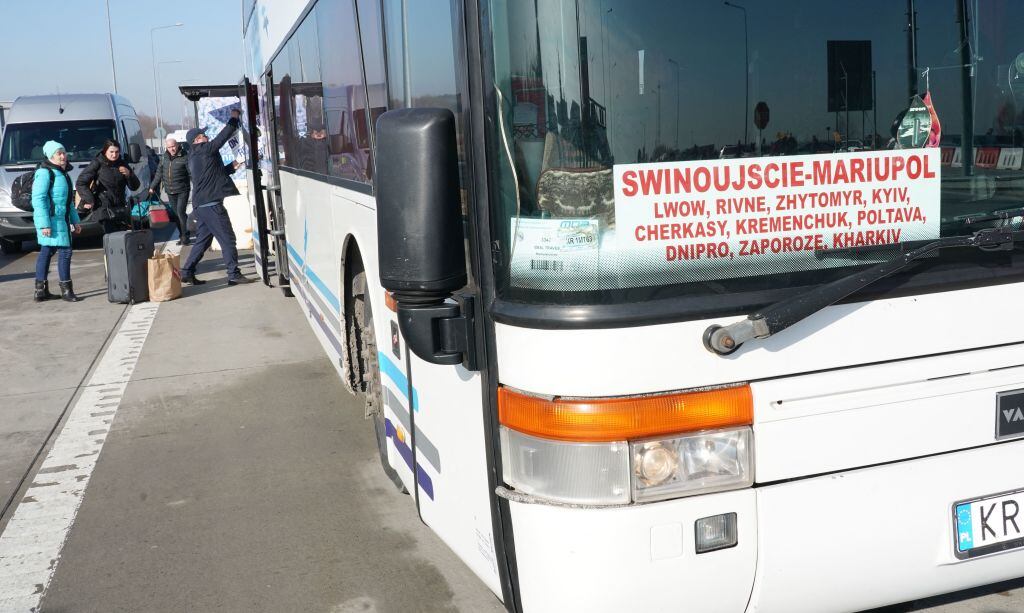 Ukrainian citizens are seen in front of a bus linking the Polish city of Swinoujscie with the Ukrainian city of Mariupol as they cross the border from Ukraine to Poland at the Korczowa-Krakovets border crossing on February 26, 2022, following the Russian invasion of Ukraine. - The UN said more than 50,000 Ukrainians had fled the country in the past two days, calling for "safe unimpeded access" for aid operations. Streams of people in cars and on foot were seen crossing into Hungary, Poland and Romania. (Photo by JANEK SKARZYNSKI / AFP) (Photo by JANEK SKARZYNSKI/AFP via Getty Images)