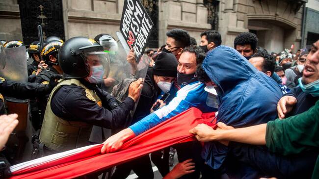 Supporters of ousted Peruvian President Martin Vizcarra, who was removed in an impeachment vote late Monday, struggle with riot police as they demonstrate against the new government in Lima on November 10, 2020. - Speaker of Congress Manuel Merino assumed office Tuesday as Peru's third president in four years, amid street protests and market jitters after the impeachment of Martin Vizcarra over corruption allegations. (Photo by Ernesto BENAVIDES / AFP) (Photo by ERNESTO BENAVIDES/AFP via Getty Images)