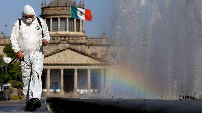 TOPSHOT - A worker wearing a protective suit sprays disinfectant during a campaign to sanitize public spaces as a preventive measure against the spread of the new coronavirus, COVID-19, in Guadalajara, Mexico, on March 20, 2020. (Photo by ULISES RUIZ / AFP) (Photo by ULISES RUIZ/AFP via Getty Images)