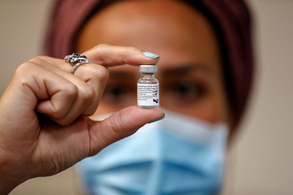 Trabajadora de la salud de Israel sostiene una dosis de la vacuna de Pfizer