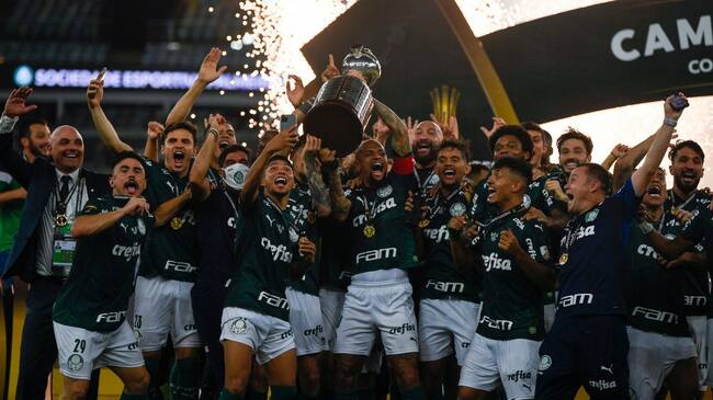 RIO DE JANEIRO, BRAZIL - JANUARY 30: Players of Palmeiras celebrate with the trophy on the podium after winning the final of Copa CONMEBOL Libertadores 2020 between Palmeiras and Santos at Maracanã Stadium on January 30, 2021 in Rio de Janeiro, Brazil. (Photo by Mauro Pimentel – Pool/Getty Images)