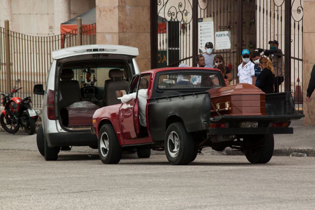 GUAYAQUIL, ECUADOR - APRIL 10: People in trucks make a line and wait outside Jardines de Esperanza cemetery in Guayaquil, with coffins to be buried on April 10, 2020 in Pascuales, Guayaquil, Ecuador. Guayas Province and its capital Guayaquil are the epicenter of the COVID-19 pandemic in Ecuador, the worst-hit per capita country in South America. Morgues and hospitals are overcrowded and government started burials in common graves in the boroughs of Pascuales and La Aurora. Number of deaths is expected to be much higher as most victims were not tested nor diagnosed.  (Photo by Getty Images/Eduardo Maquilon/Getty Images)
