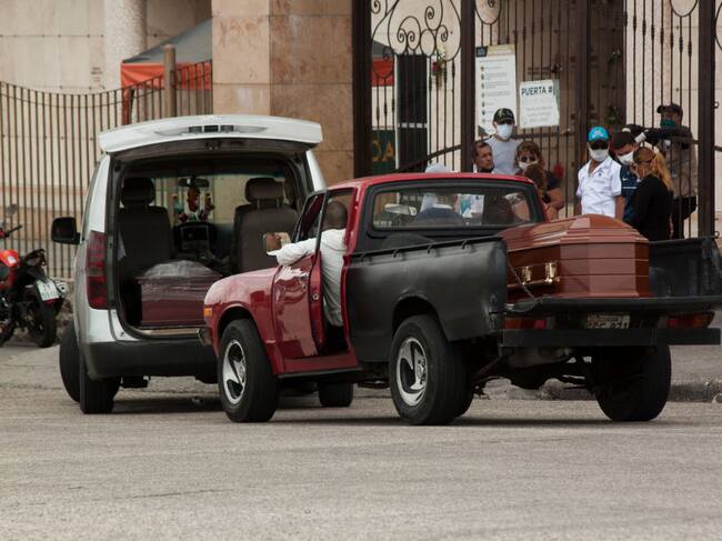 GUAYAQUIL, ECUADOR - APRIL 10: People in trucks make a line and wait outside Jardines de Esperanza cemetery in Guayaquil, with coffins to be buried on April 10, 2020 in Pascuales, Guayaquil, Ecuador. Guayas Province and its capital Guayaquil are the epicenter of the COVID-19 pandemic in Ecuador, the worst-hit per capita country in South America. Morgues and hospitals are overcrowded and government started burials in common graves in the boroughs of Pascuales and La Aurora. Number of deaths is expected to be much higher as most victims were not tested nor diagnosed. (Photo by Getty Images/Eduardo Maquilon/Getty Images)