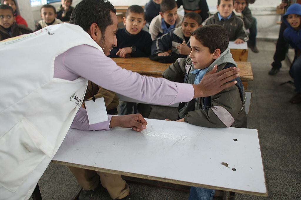 Voluntarios ayudan a un grupo de niños en una escuela de Gaza