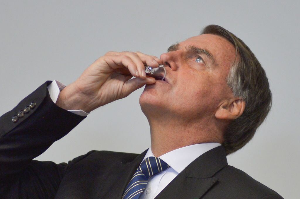 El presidente brasilero Jair Bolsonaro bebe durante un evento