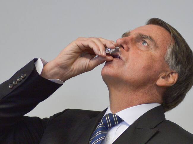 El presidente brasilero Jair Bolsonaro bebe durante un evento