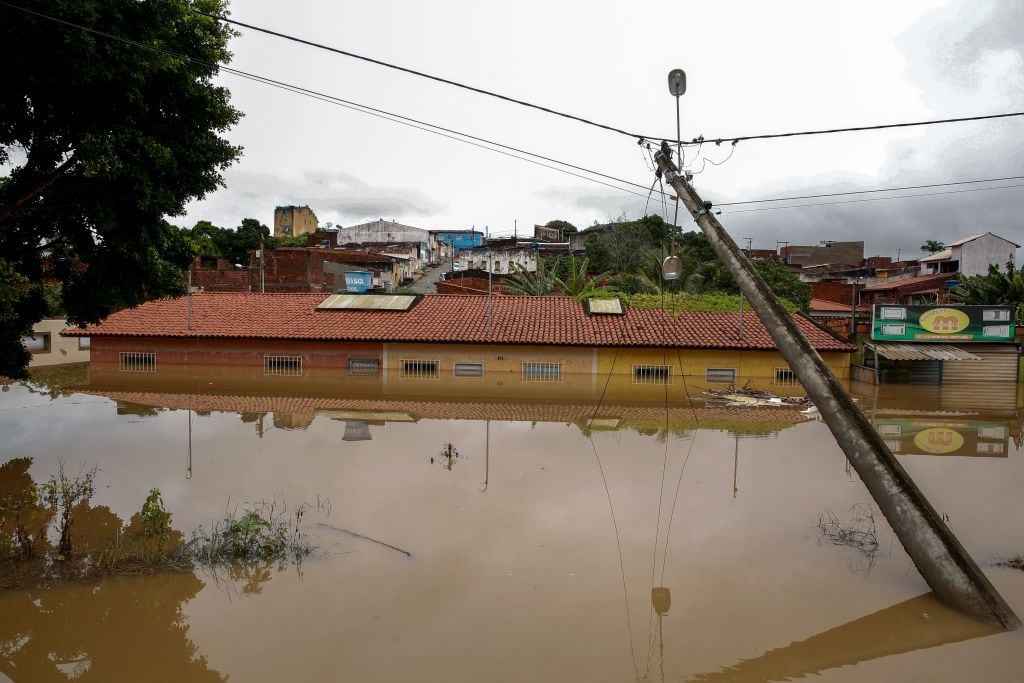 Un poste eléctrico cerca del agua que cubre una vivienda en Itapetinga