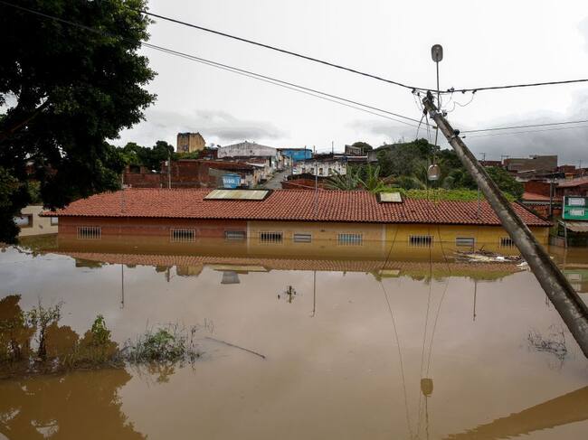 Un poste eléctrico cerca del agua que cubre una vivienda en Itapetinga