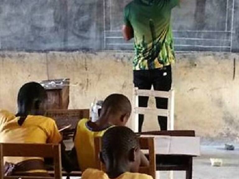 Un profesor africano enseña Word dibujando con tiza en una pizarra