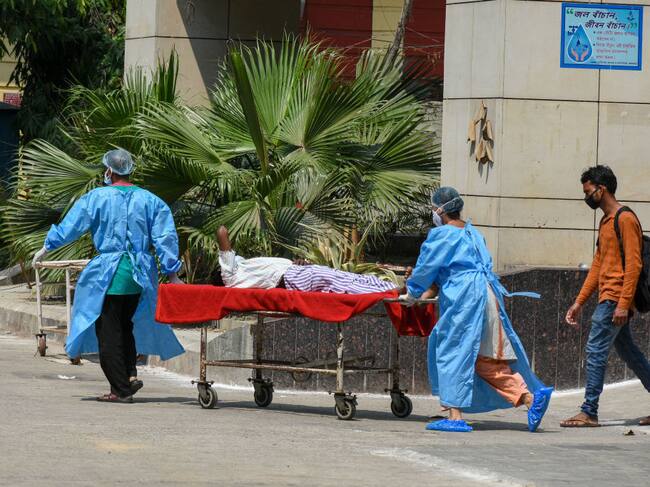 Trabajadores de la salud ingresan con urgencia a un paciente Covid-19 en India