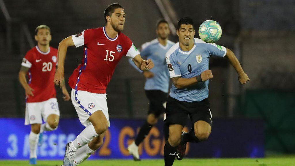 MONTEVIDEO, URUGUAY - OCTOBER 08: Luis Suarez of Uruguay fights for the ball with Francisco Sierralta of Chile during a match between Uruguay and Chile as part of South American Qualifiers for Qatar 2022 at Centenario Stadium on October 08, 2020 in Montevideo, Uruguay. (Photo by Raul Martinez -Pool/Getty Images)