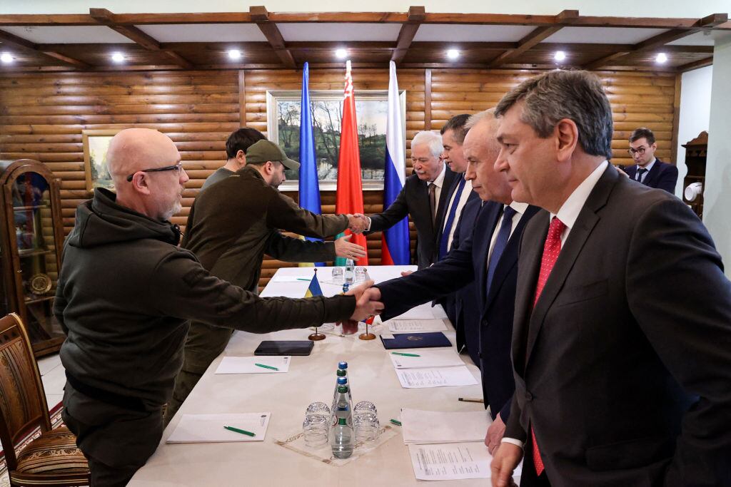 TOPSHOT - Ukrainian Defence minister Oleksii Reznikov (L) shakes hands with Russian negotiators prior the talks between delegations from Ukraine and Russia in Belarus' Brest region on March 3, 2022, following the Russian invasion of Ukraine. - Russia and Ukraine will discuss a ceasefire at upcoming talks on the border between Poland and Belarus, Moscow's chief negotiator said on March 2, nearly one week into Russia's invasion of its pro-Western neighbour. - Belarus OUT (Photo by Maxim GUCHEK / BELTA / AFP) / Belarus OUT (Photo by MAXIM GUCHEK/BELTA/AFP via Getty Images)