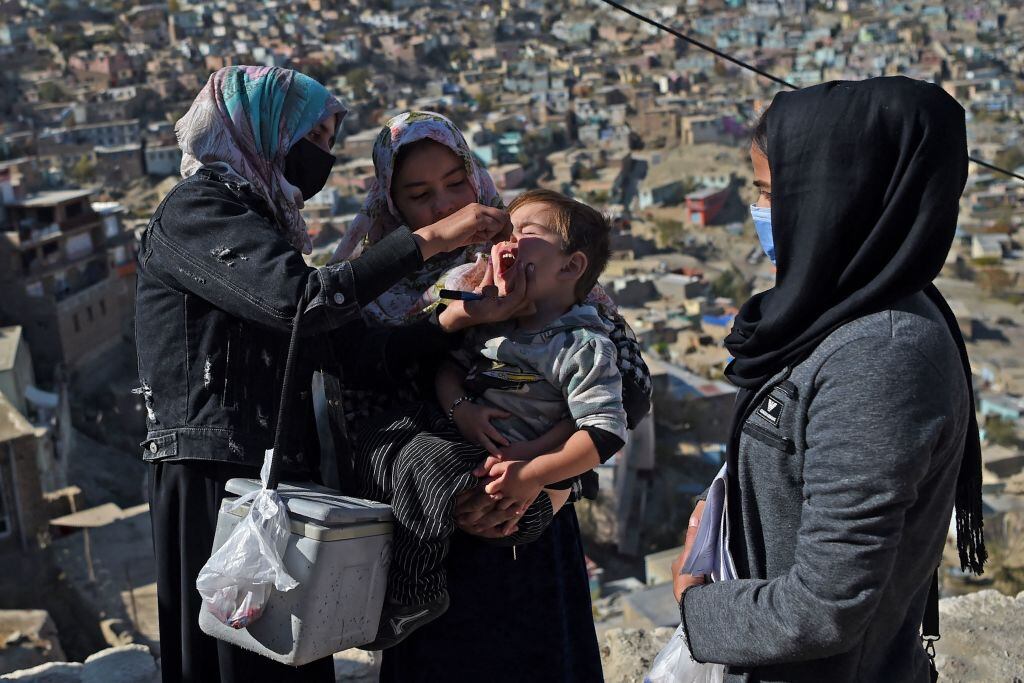 Trabajadora de la salud da la vacuna contra la polio a un niño en Kabul