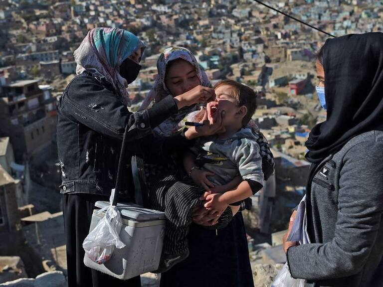 Trabajadora de la salud da la vacuna contra la polio a un niño en Kabul